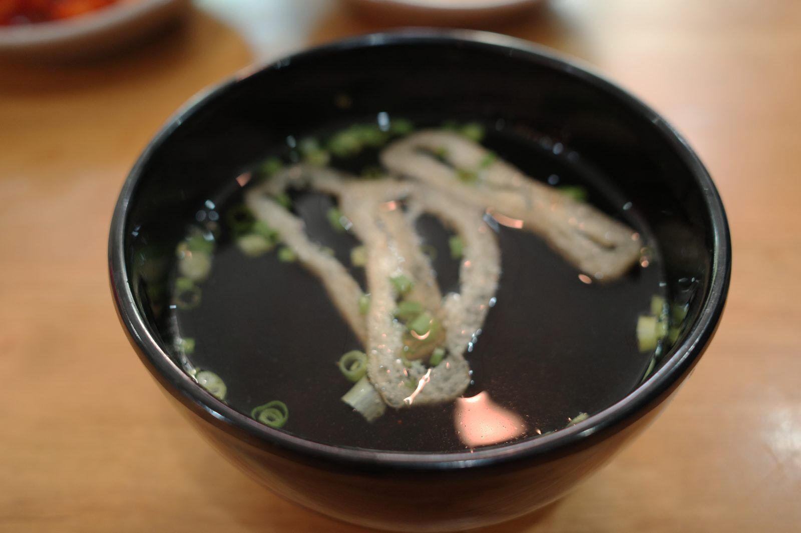 Bowl of Korean fish cake soup with spring onions served as a side dish in Da Nang
