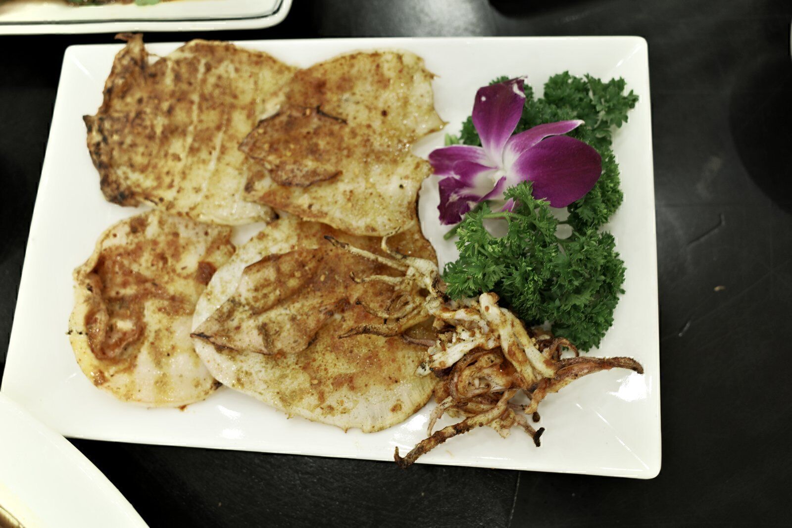 Plate of grilled squid with garnish at a seafood restaurant in Da Nang