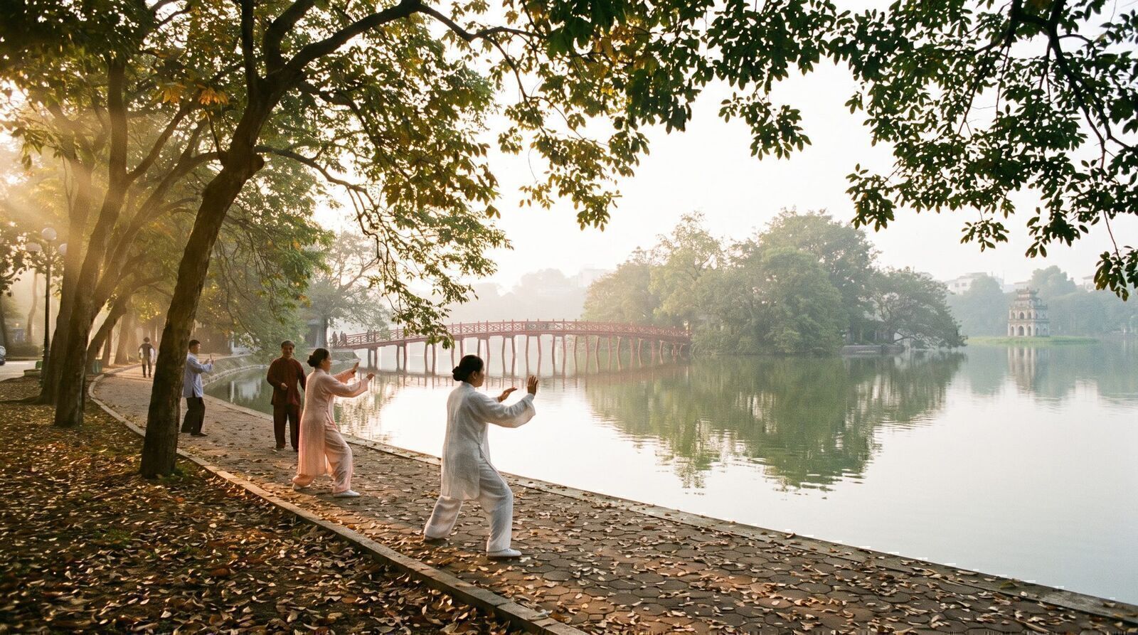 Early autumn morning tai chi by Hoan Kiem Lake in Hanoi with the red Huc Bridge in the background