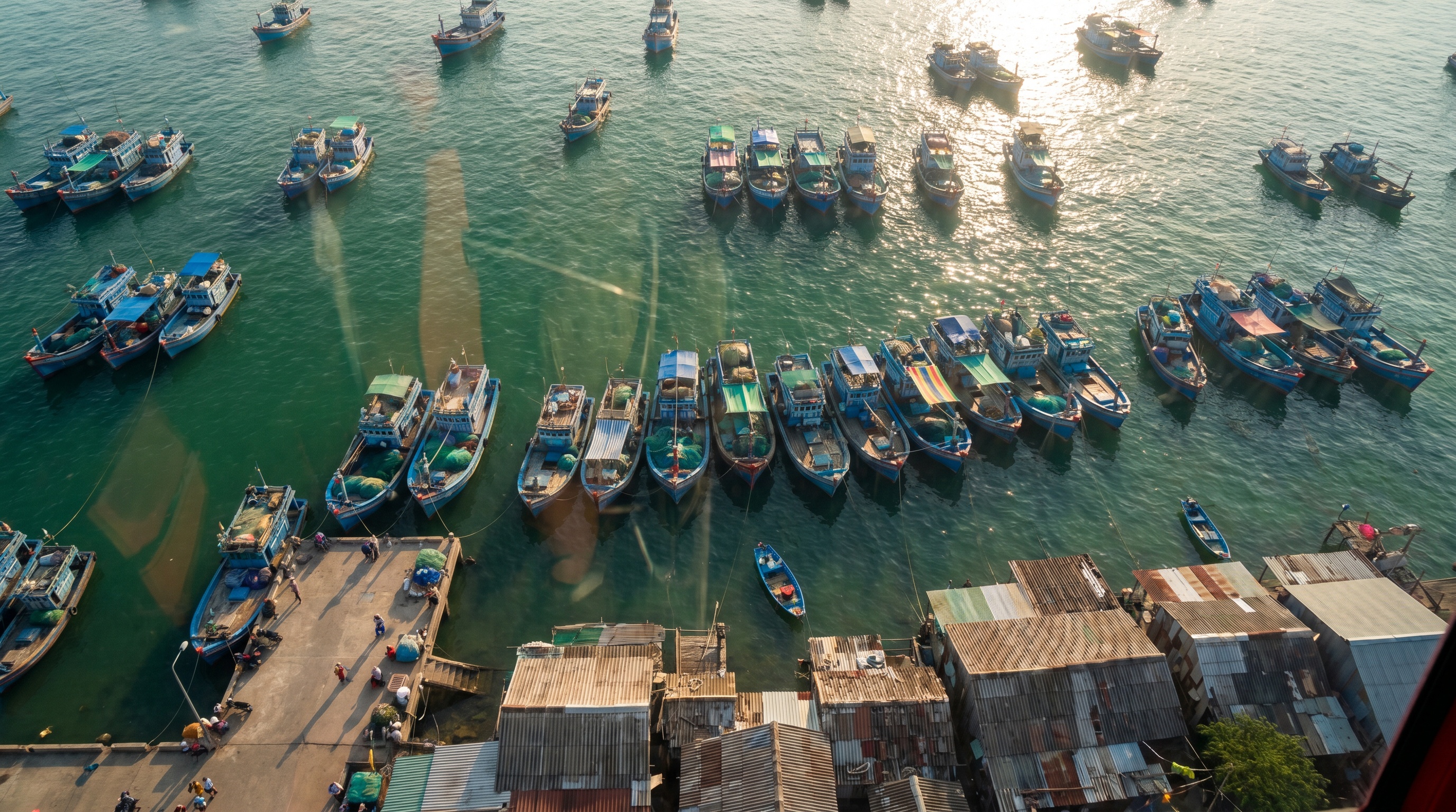Aerial view of blue fishing boats in turquoise water at An Thoi harbor from the Hon Thom cable car