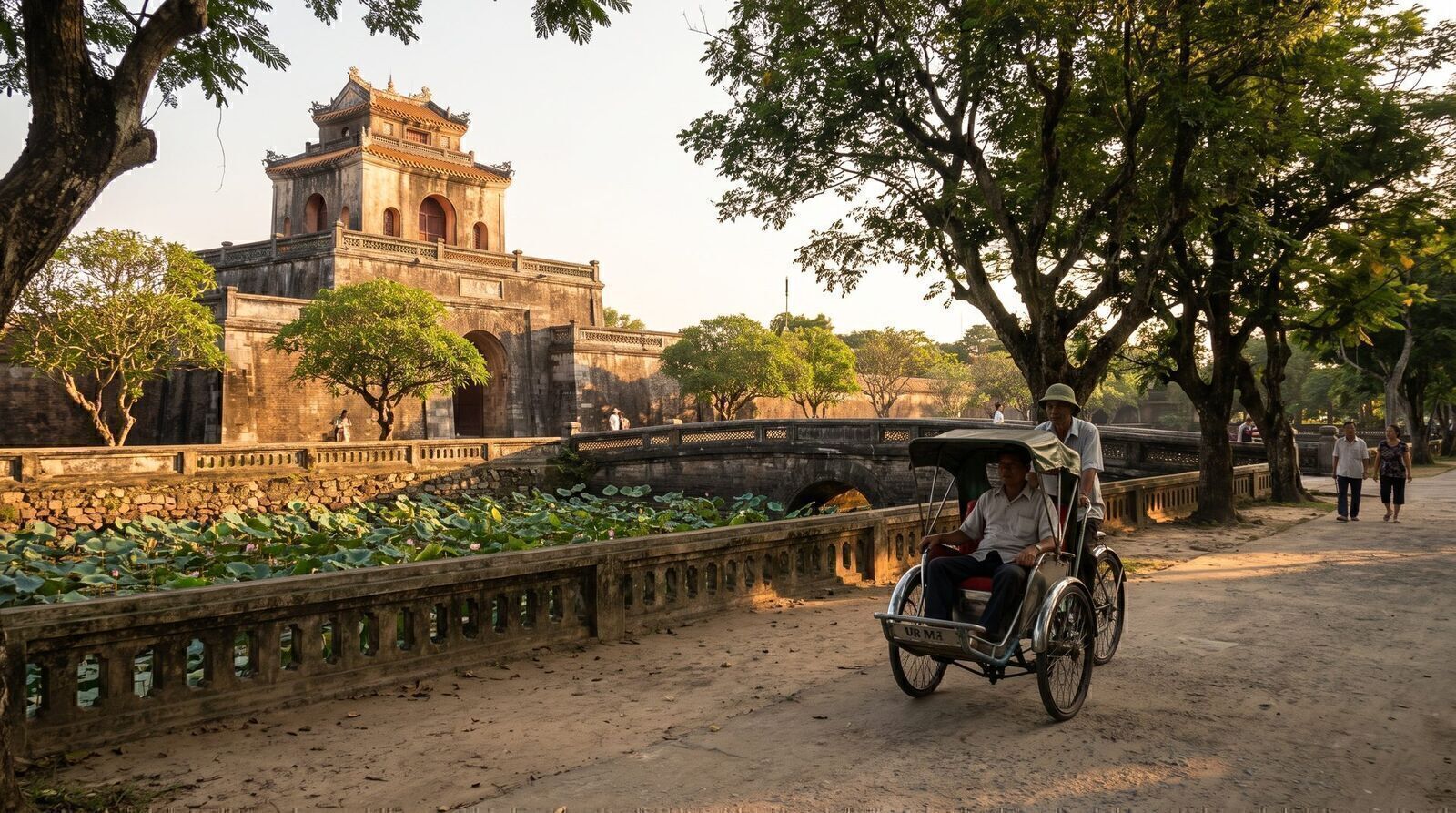 Cyclo passing the lotus moat and gate of Hue Imperial City in golden May evening light
