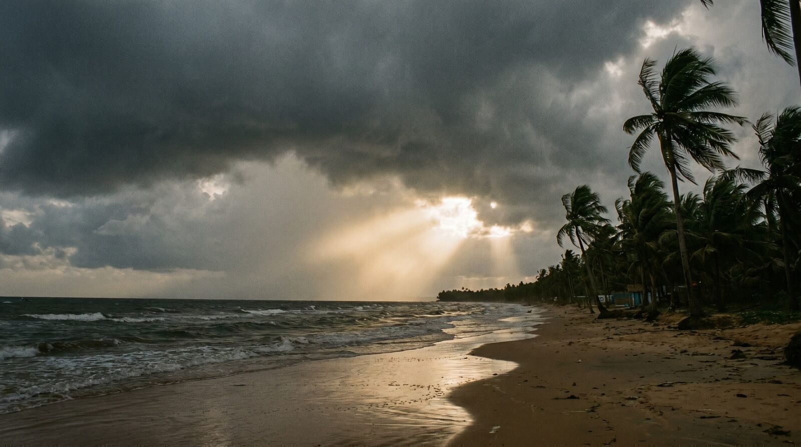 Dramatic September monsoon clouds with sunlight break over an empty Phu Quoc beach