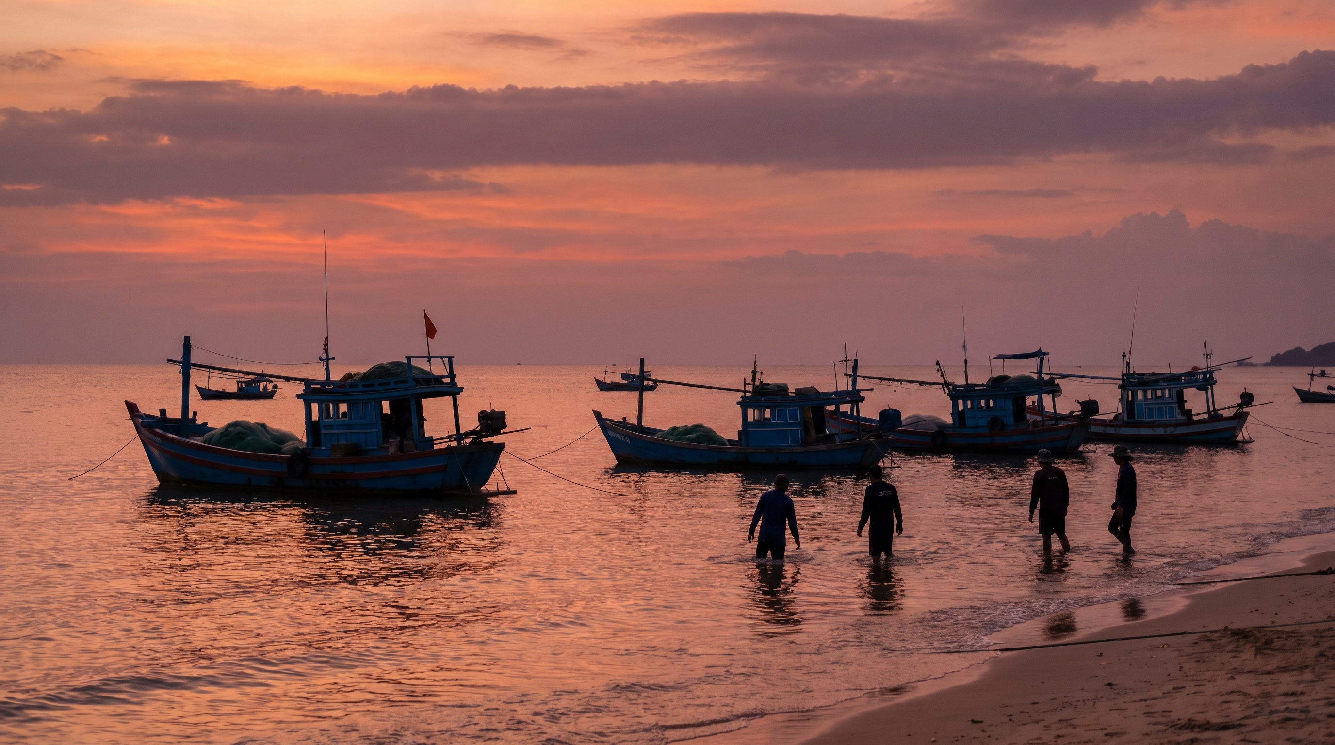 Fishing boats silhouetted against an orange sunset off Phu Quoc's west coast