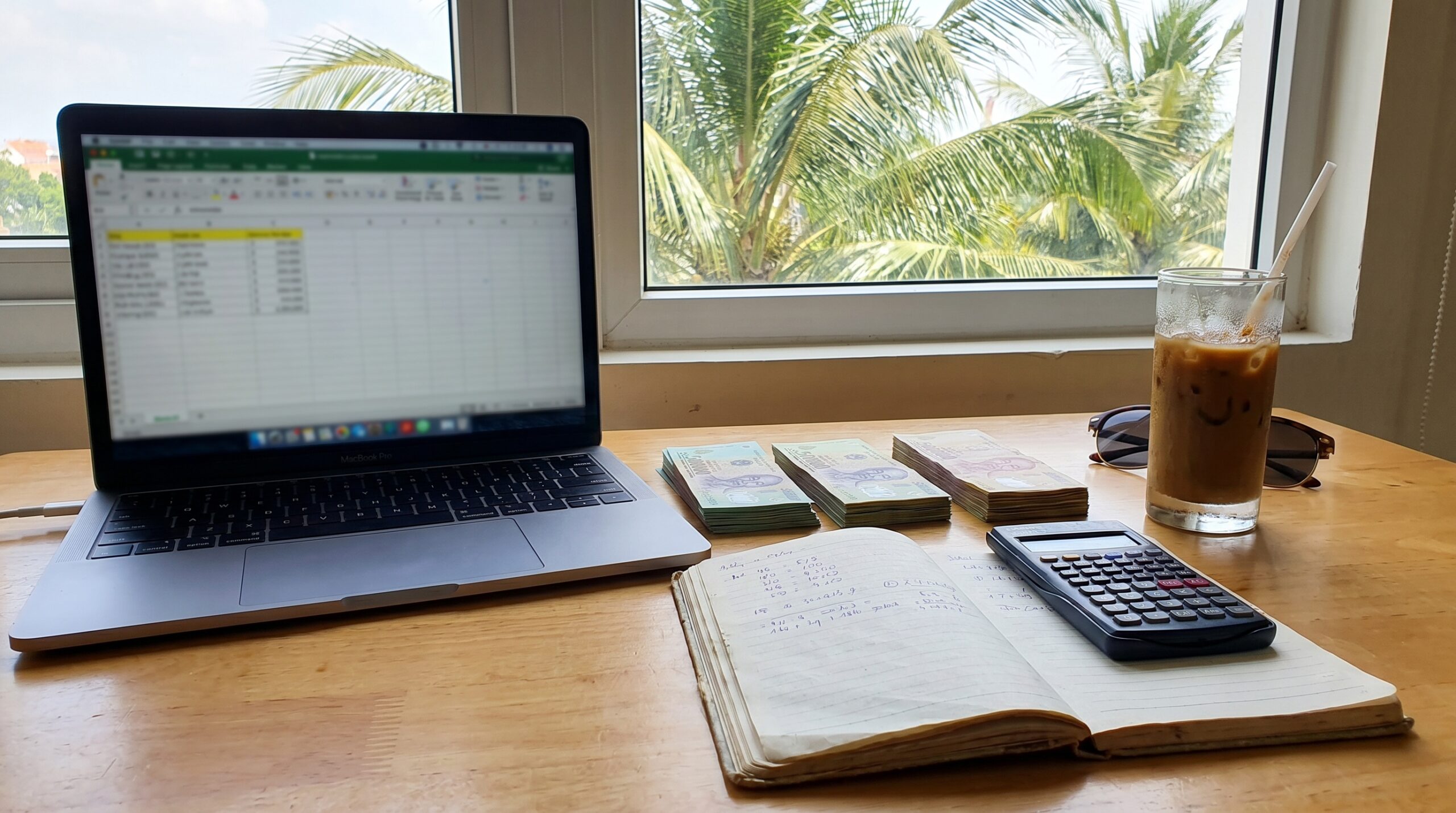 Laptop Vietnamese dong and expense notebook for monthly budget planning