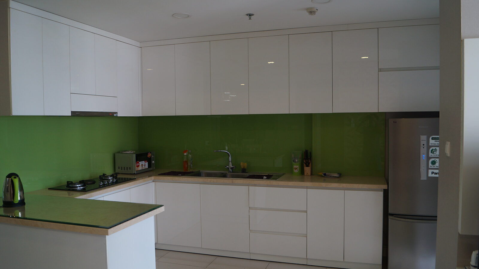 Kitchen of a monthly rental apartment in Vietnam with full cabinets and appliances