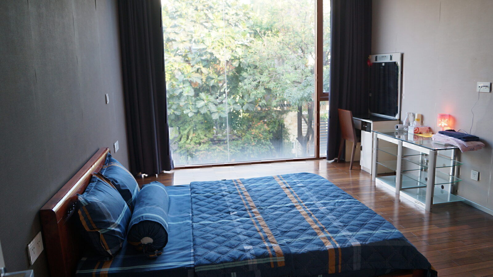 Bright Vietnamese guesthouse bedroom with a garden view through floor to ceiling window