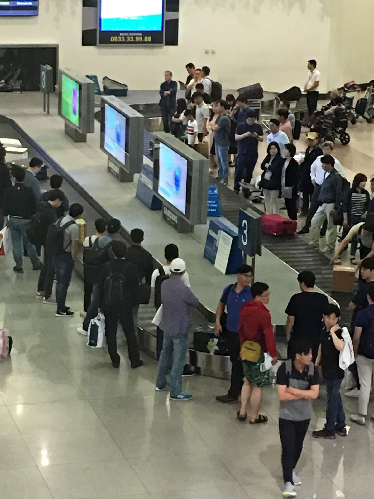 Arrivals hall at Tan Son Nhat airport in Ho Chi Minh City, travelers waiting at baggage belt 3