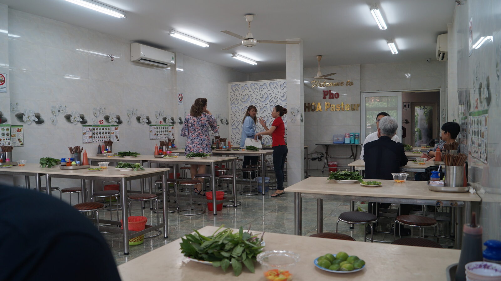 Interior of Pho Hoa Pasteur in Saigon with herb plates and limes preset on every table